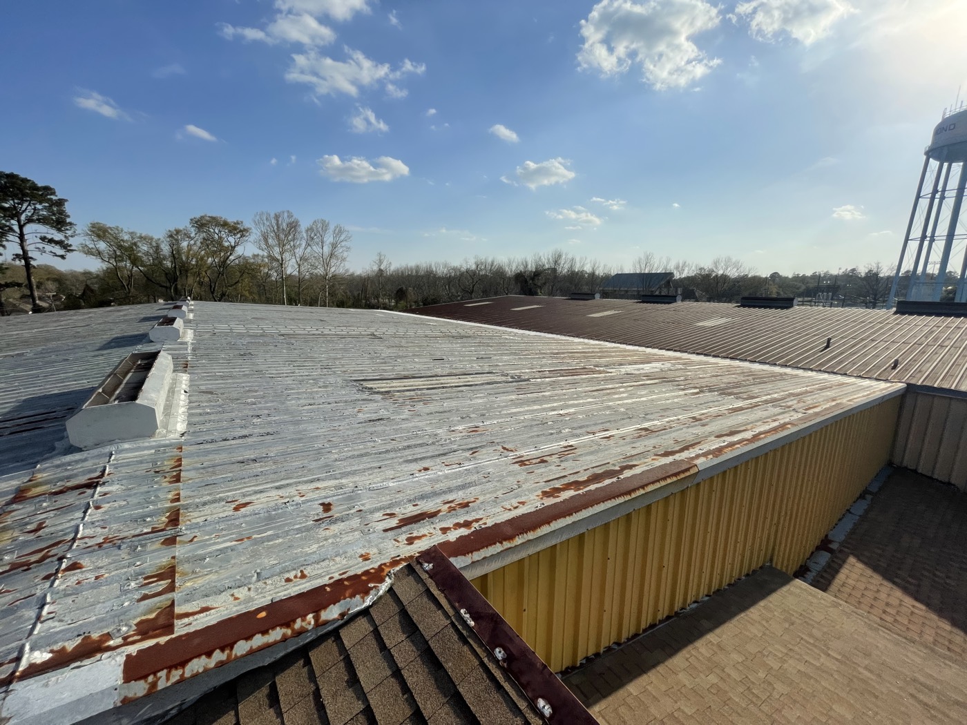 Weathered and rusting metal roofing on the warehouse, photographed during the inspection